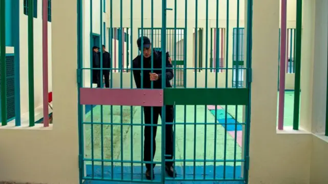 A Moroccan prison warder closes a gate in a prison