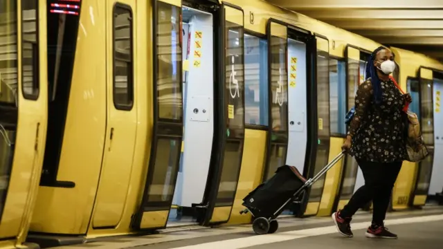 A woman gets off a metro train in Berlin wearing a face mask