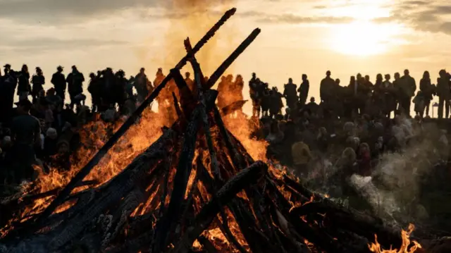 People gather around a May bonfire celebrating Walpurgis Eve in Malmo, southern Sweden, on April 30, 2019