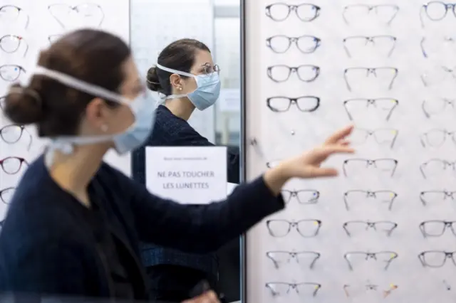 A woman wears a mask inside an opticians in Switzerland