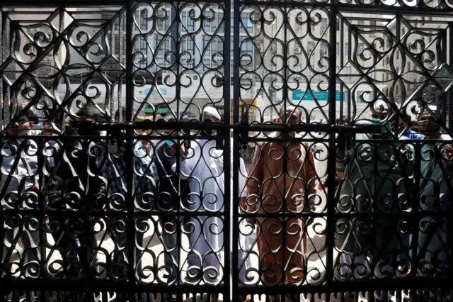 People stand outside the locked entrance gate of a mosque as they arrive to attend Friday prayer despite a lockdown after Pakistan shut all markets, public places and discouraged large gatherings amid an outbreak of coronavirus disease (COVID-19), in Karachi, Pakistan March 27, 2020.