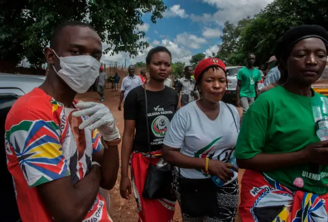 A political supporter wears a face mask and gloves at an event in Lilongwe