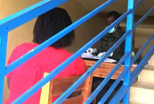 A Rwandan woman speaks to a soldier