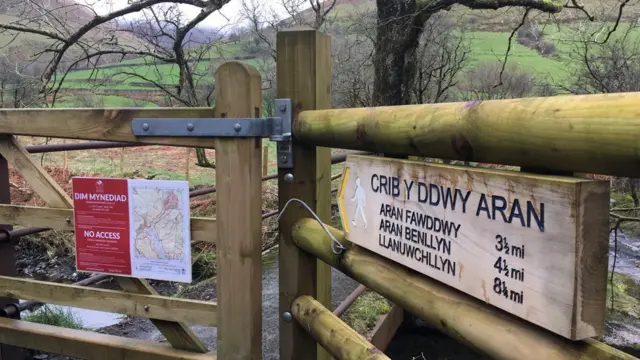 A sign on a gate indicating a footpath in Wales is closed