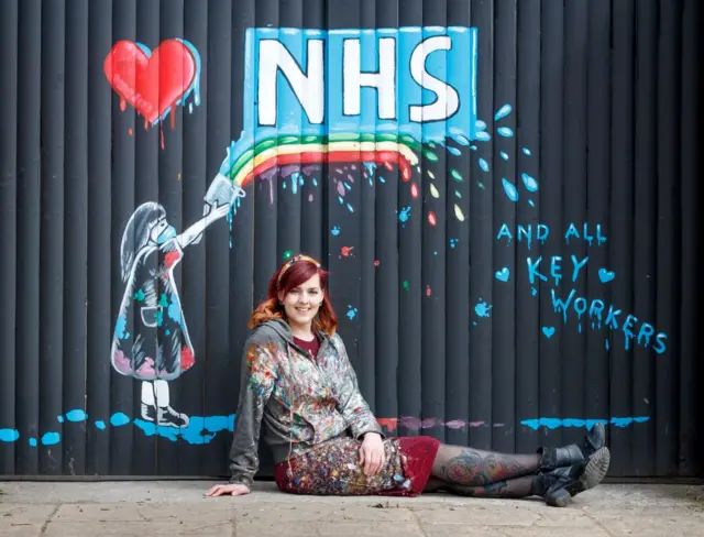 Artist Rachel List with her mural supporting the NHS on the gates of the Hope & Anchor pub in Pontefract, Yorkshire,