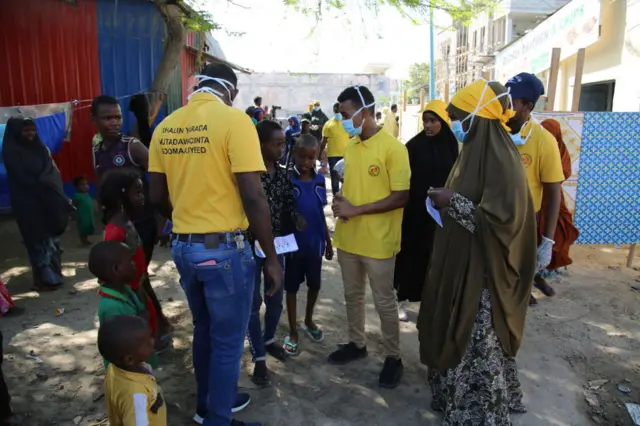 A group of volunteers distribute cleaning supplies at a refugee camp in Mogadishu, Somalia