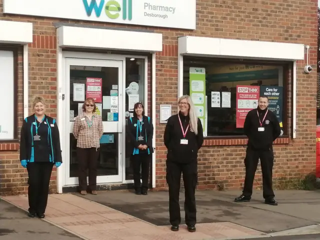 People outside a pharmacy