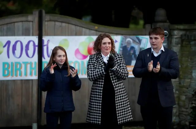 The family of Retired British Army Captain Tom Moore, daughter Hannah Ingram-Moore and grandchildren Benji and Georgia applaud outside his home during the Clap for our Carers campaign in support of the NHS, following the outbreak of the coronavirus disease (COVID-19), in Marston Moretaine, Britain,