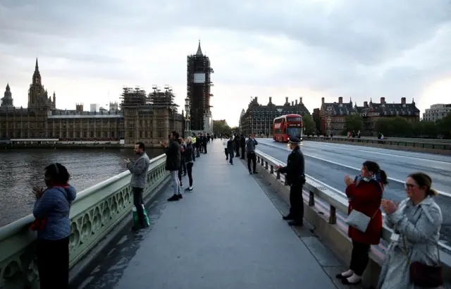 People applaud on Westminster Bridge in support of the NHS is seen before the Clap for our Carers campaign, following the outbreak of the coronavirus disease (COVID-19), in London, Britain,