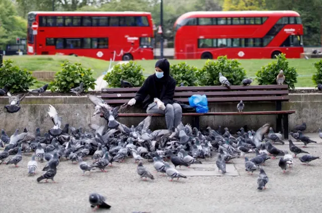 Woman feeding pigeons