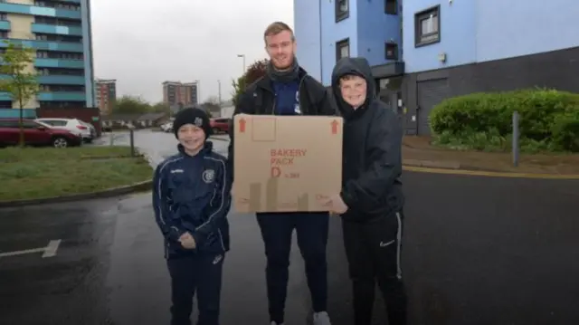 Chris Brunt with his sons and a box