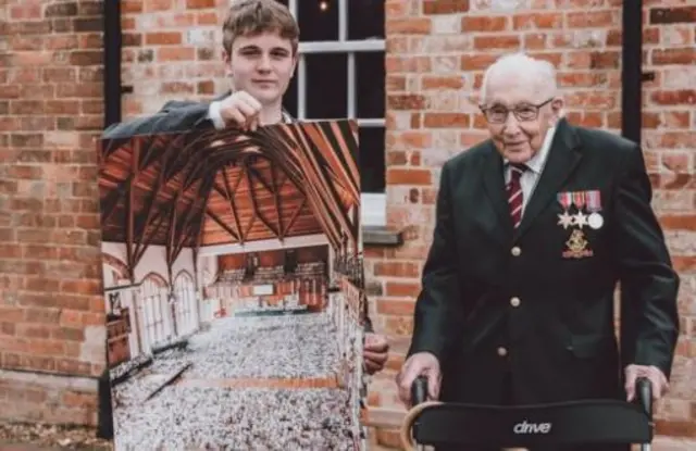 Benjie Ingram-Moore presenting his grandfather with a photo of the thousands of birthday cards he has received