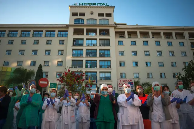 Medics clap to show gratitude to health workers in Spain on a day when the country had its lowest death toll for a week