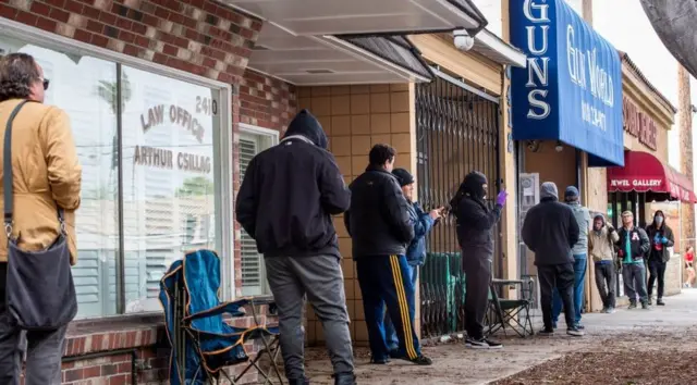 Customers queue outside a LA county gun shop last month