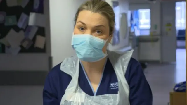 A NHS worker wears protective equipment