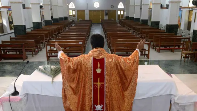 Priest performing Mass in an empty church