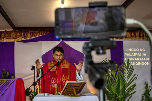 A Catholic priest in Manila live-streams his Mass for people worshipping at home