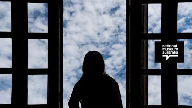 Silhouette of girl looking out a window