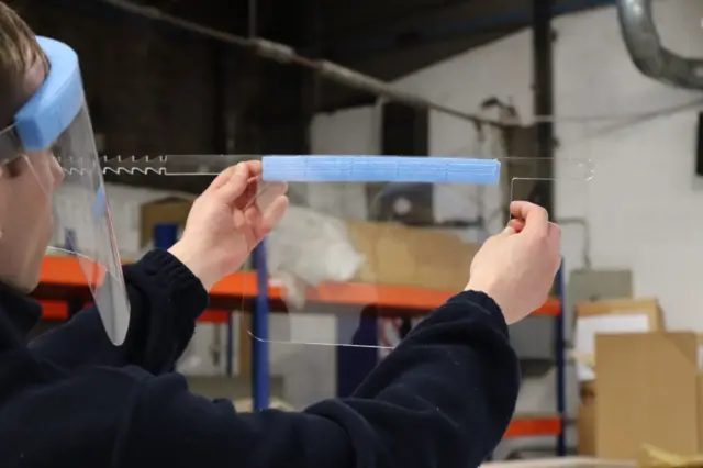 ICL worker checks visors during the production process