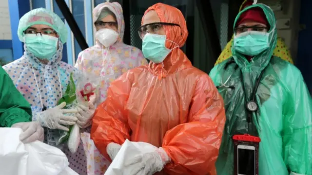 Medical workers wearing rain coats as PPE