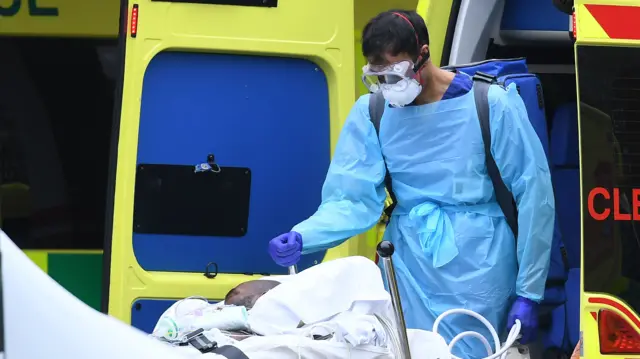 A patient is taken from an ambulance into St Thomas' Hospital in north London