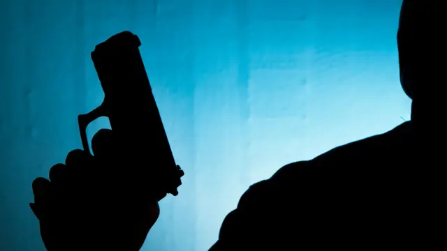 Person with gun in silhouette