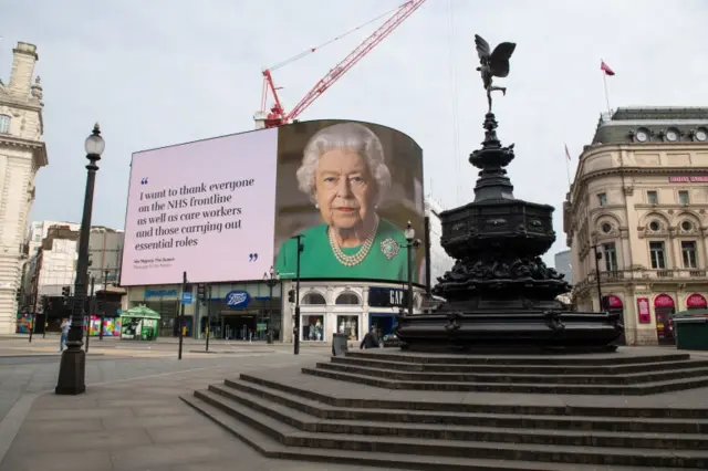 A billboard featuring a picture of and message from the Queen