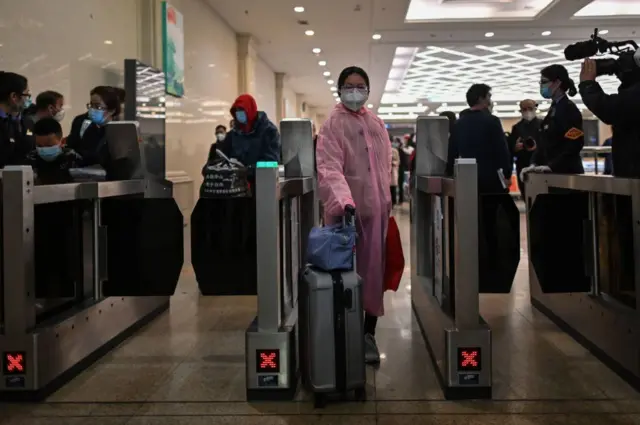 A woman wearing a face mask arrives at Hankou Railway Station in Wuhan