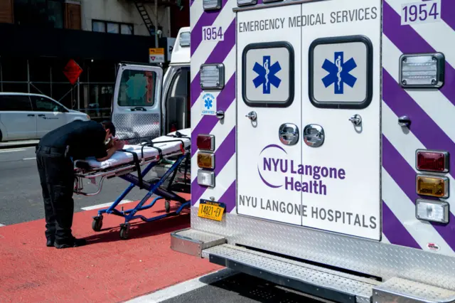 A EMT takes a moment in front of NYU Langone Hospital on April 7