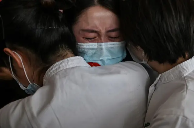 Medical staff from Jilin Province (C) hug nurses from Wuhan after working together during the COVID-19 coronavirus outbreak