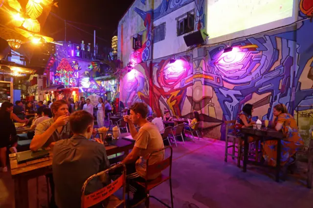 People mingle over food and drinks at a restaurant on March 25, 2020 in Singapore