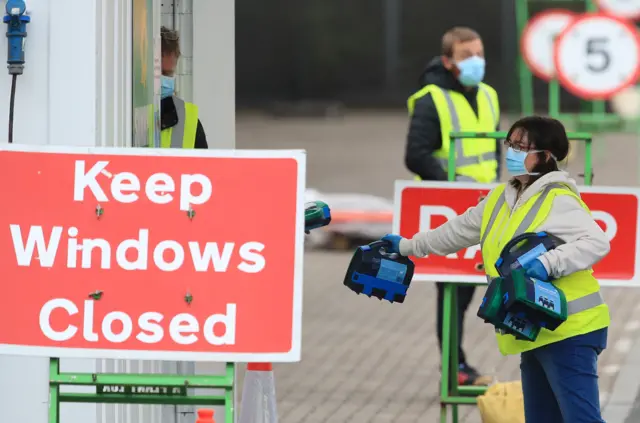 A member of staff hands a first aid kit to a colleague at the coronavirus testing centre which has been set up for the testing of NHS staff at Ikea in Gateshead.