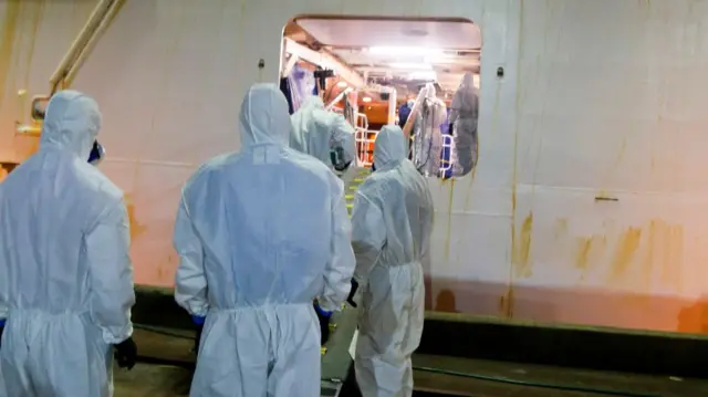 Police officers in full protective gear board the Ruby Princess