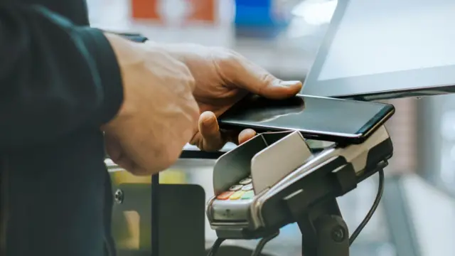 Man using phone to pay by contactless payment
