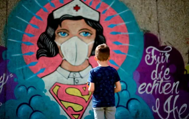 Street art in Germany showing a nurse with the Superman logo on her uniform