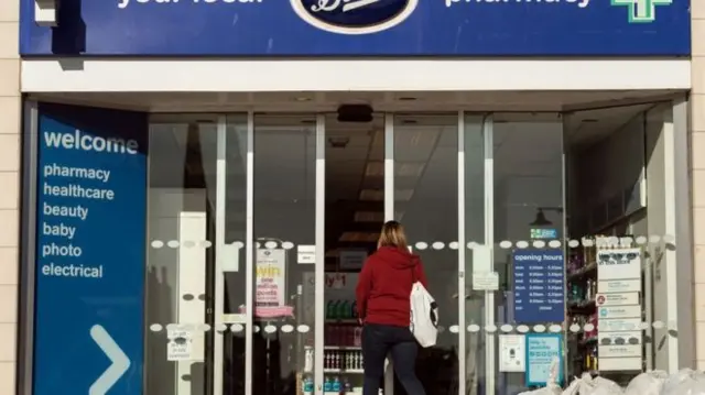 Woman walking into Boots shop