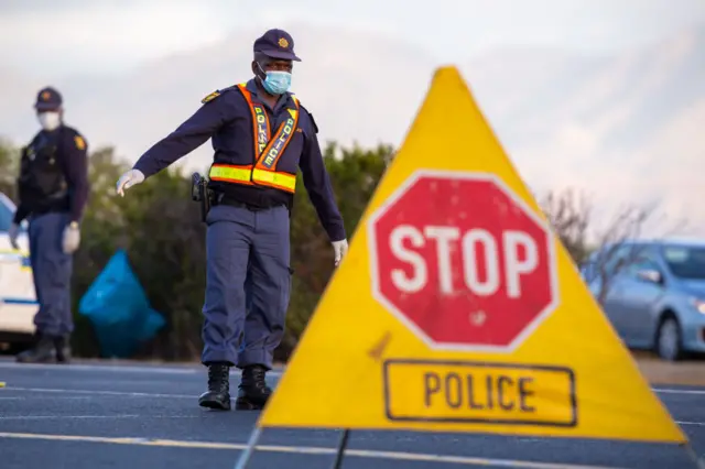 A police officer of the South African Police Service manning a 24-hour roadblock