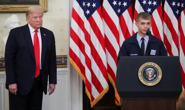 US. President Donald Trump listens as 23-year-old mail carrier Kyle West of Cincinnati, Ohio