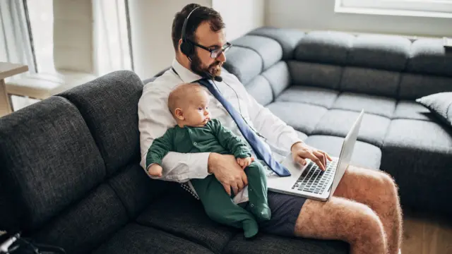 Man working from home holding a baby