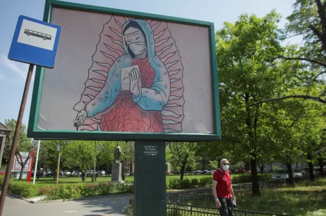 An outdoor poster shows a doctor depicted in a style similar to religious paintings, in Bucharest, Romania, on 29 April 2020.