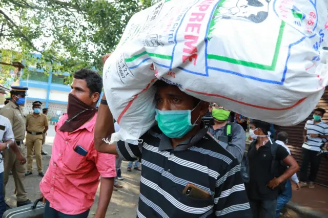 Stranded migrant workers arrive at Aluva railway station to board a special train to Odisha