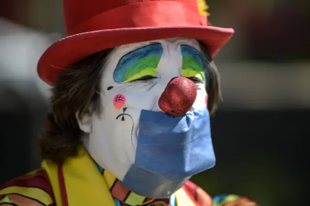 A clown wears a protective mask during a protest to demand Mexican government aid, Mexico City, on April 30, 2020