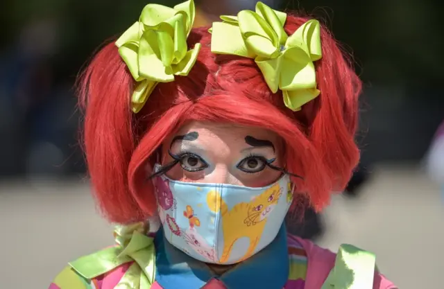 A clown wears a protective mask during a protest to demand Mexican government aid, Mexico City, on April 30, 2020