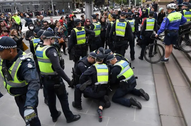 An anti-lockdown protester is arrested by police on the steps of Victoria's state parliament in Melbourne