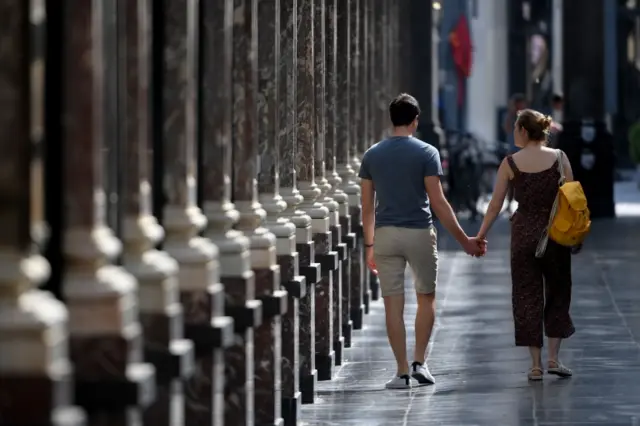 A couple walk through Brussels on 9 May after the country's lockdown was eased