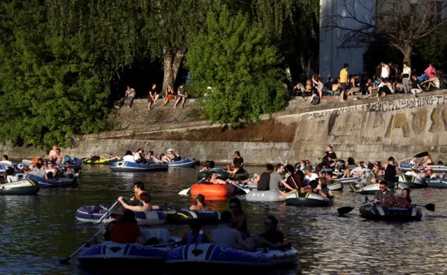 People enjoy sun on boats, on the Landwehrkanal, amid the spread of the coronavirus, in Berlin