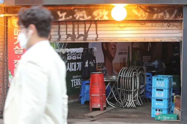 A man walks past a bar in Seoul