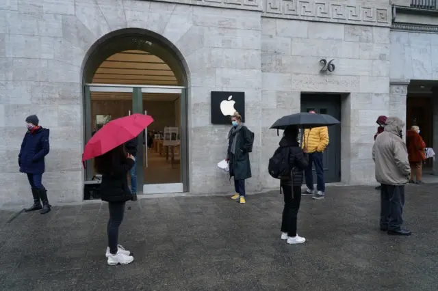 People social-distance as they queue to enter an Apple shop in Berlin, Germany. Photo: 11 May 2020