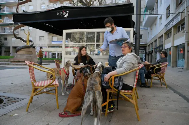 A waiter serves customers at a cafe in Spain's Tarragona on 11 May