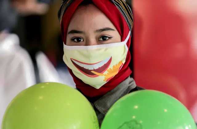 A woman looks on while wearing a face mask at a Mcdonald's Sarinah.